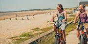 two people on ebikes looking at the beach