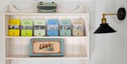 A shelf with six books and a radio and a embroidered picture that says LUDO