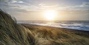 Sand dunes at littlehampton west beach at sunset with waves and sand