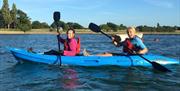 friends kayaking on Chichester Harbour in a blue double kayak