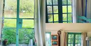 a combined image showing a comfy sofa in the living rooom and views from the windows of the gardens