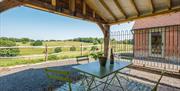 Outside, covered seating area with far reaching views across fields