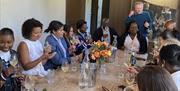 a group of people enjoying a wine tasting - seated around a large table