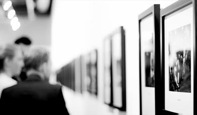 People looking at art on a wall